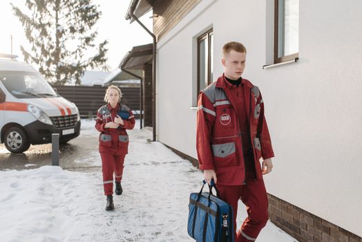 Medical professionals arriving at a snowy scene with emergency equipment.