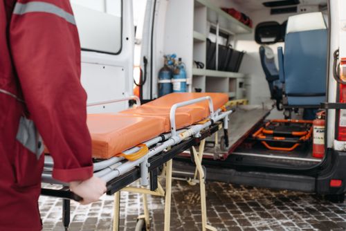 Free A paramedic loads a stretcher into an ambulance, showcasing emergency medical services in action. Stock Photo