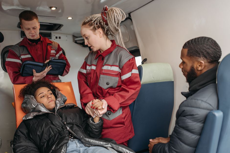 Paramedics attend to a patient inside an ambulance, providing medical care.