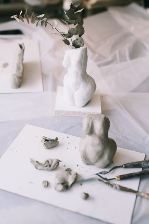 Free Clay sculptures and palette knives on table showcasing artistic creativity. Stock Photo