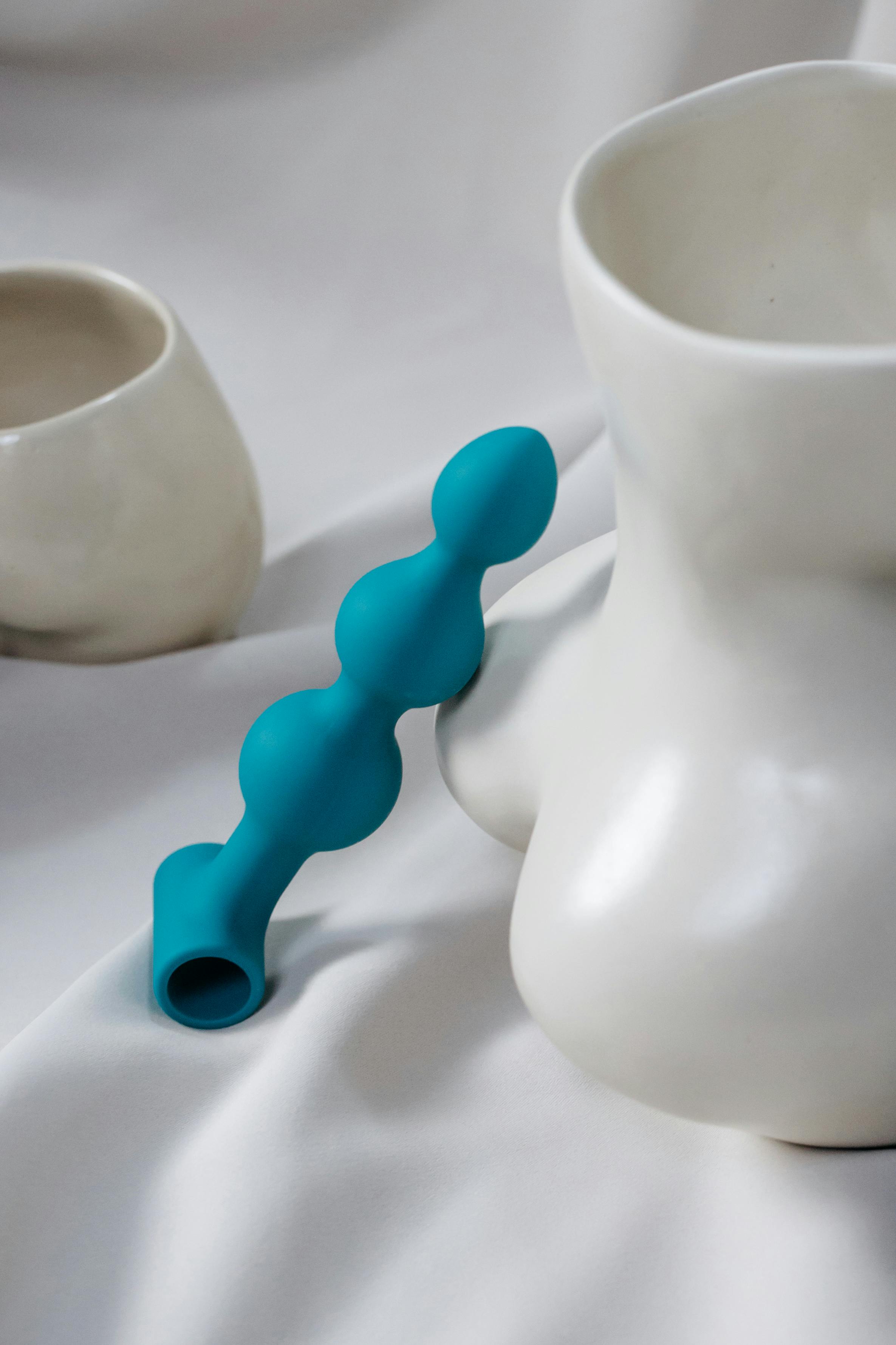 blue dildo leaning on vase in shape of naked woman