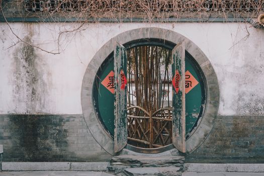 A scenic photo of a traditional circular doorway with bamboo, symbolizing Chinese architecture.