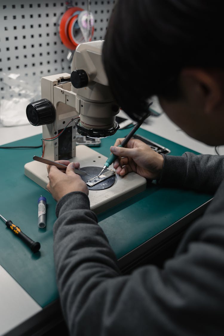 A Man Holding A Soldering Iron