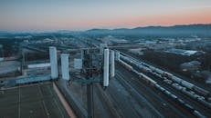 Cell tower in city suburban area with railroad station at sundown