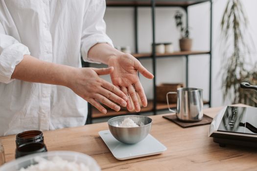 Hands preparing food in a modern kitchen, focusing on ingredients and culinary process.