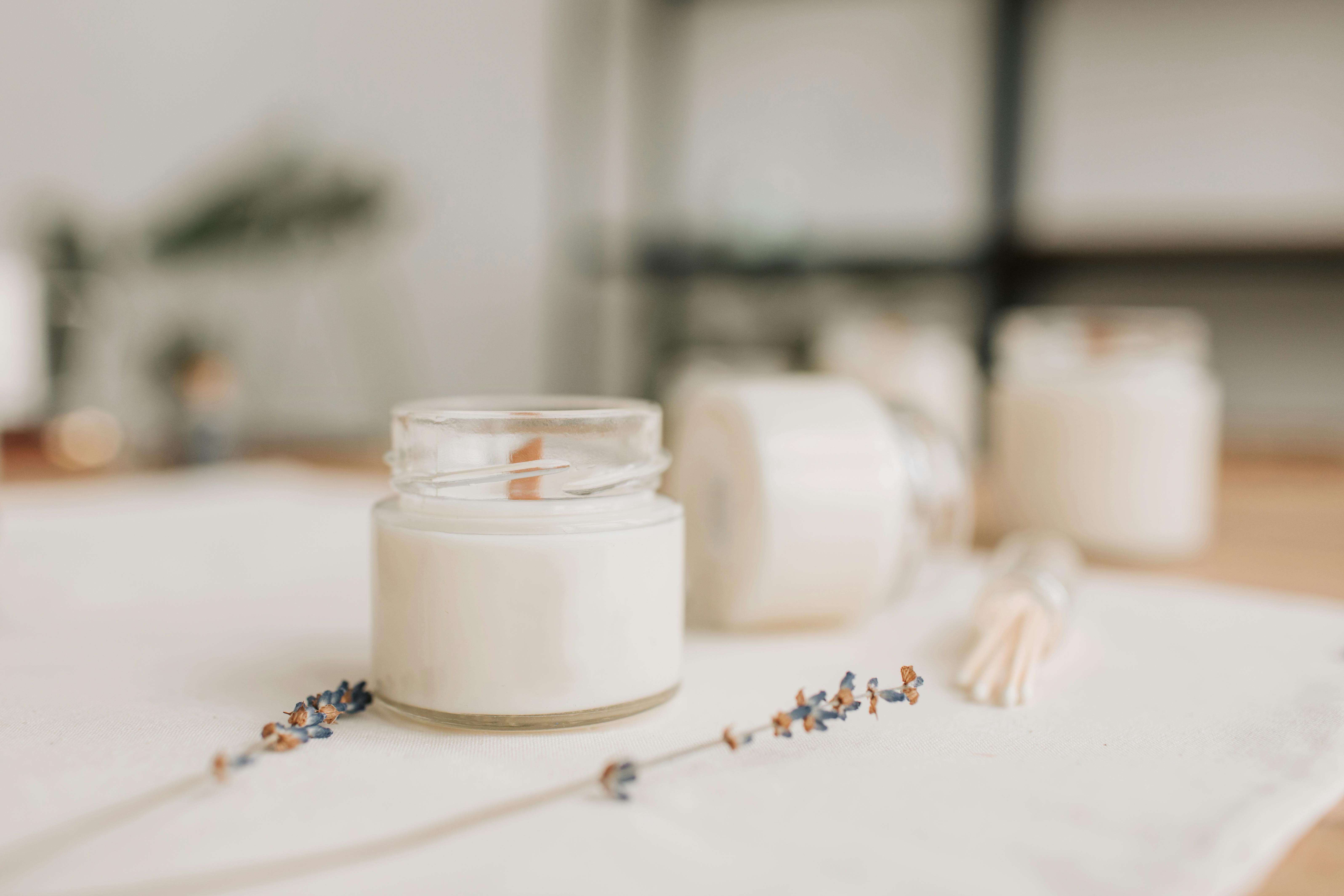 Candle near dried lavender in soft light