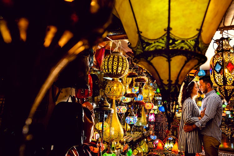 Couple Standing Face To Face Inside A Store Of Lamps