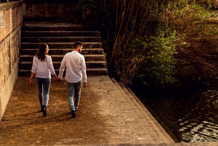 Wide Angle Shot Of A Couple Walking Past A Canal