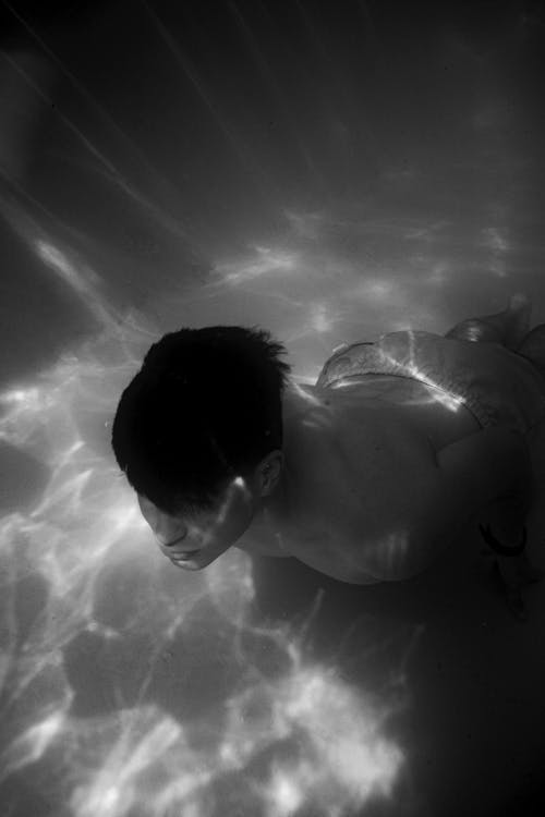 Foto profissional grátis de embaixo da água, escala de cinza, homem