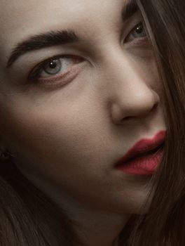 Intimate close-up portrait of a young Caucasian woman with striking makeup.