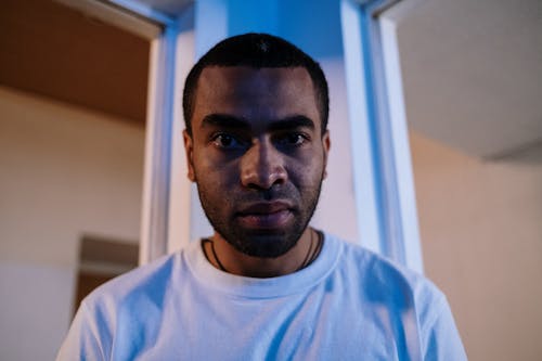 Portrait of a Young Man Sitting in a Room with Blue Lighting 