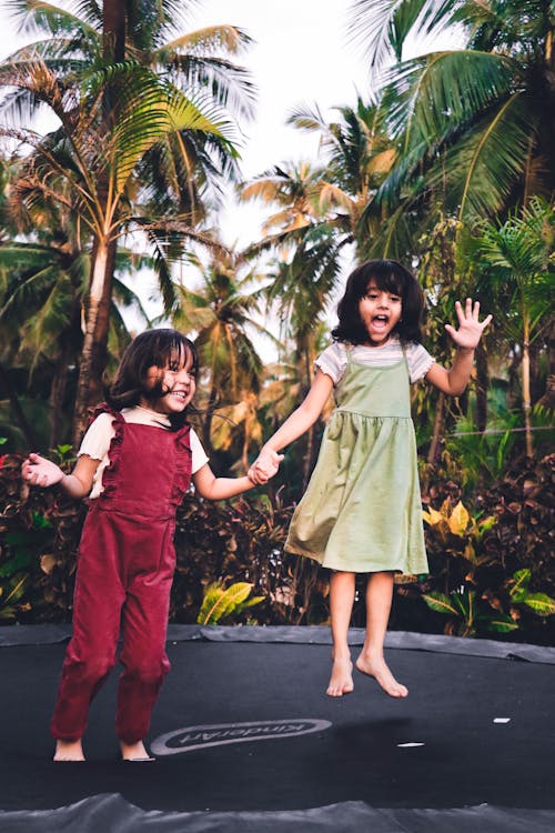 Free 2 Girls in Green Dress Standing on Gray Concrete Pathway Stock Photo