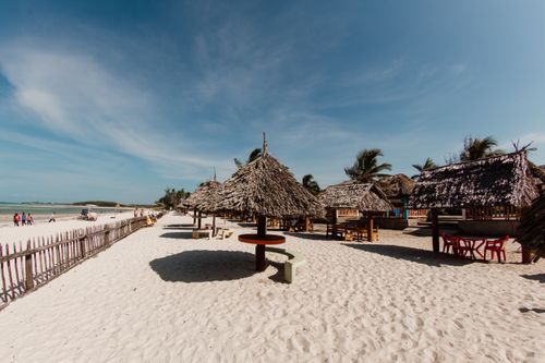 Free Serene tropical beach huts on a sunny white sand beach in Dar es Salaam, Tanzania. Stock Photo
