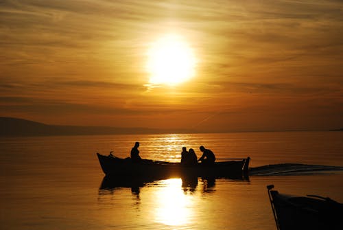 Silhouette of People Riding a Boat during Sunset