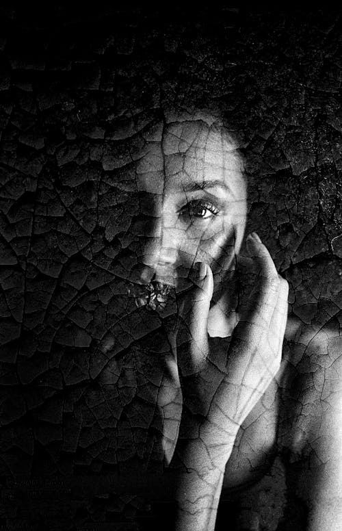 Free Gentle mysterious woman touching face in darkness Stock Photo