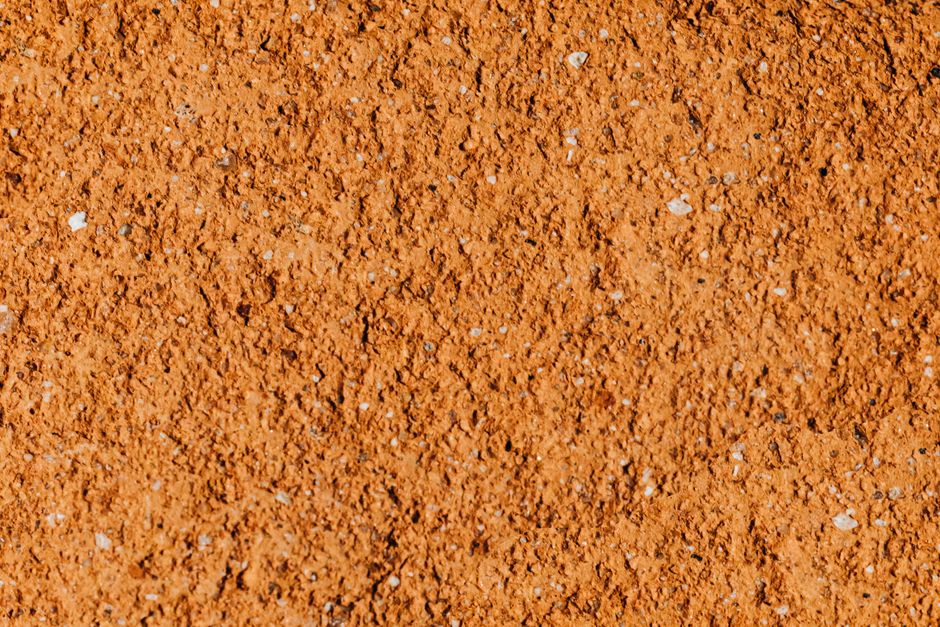 Detailed close-up of a rough, textured orange surface perfect for backgrounds or wallpapers.