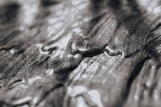 Close-up of abstract black and white textured art with shiny and wet appearance.