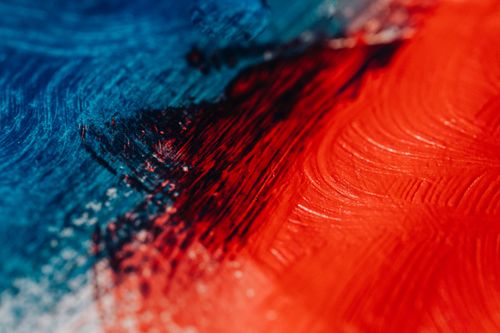 Free Close-up of a bold abstract painting with vibrant red and blue colors. Stock Photo
