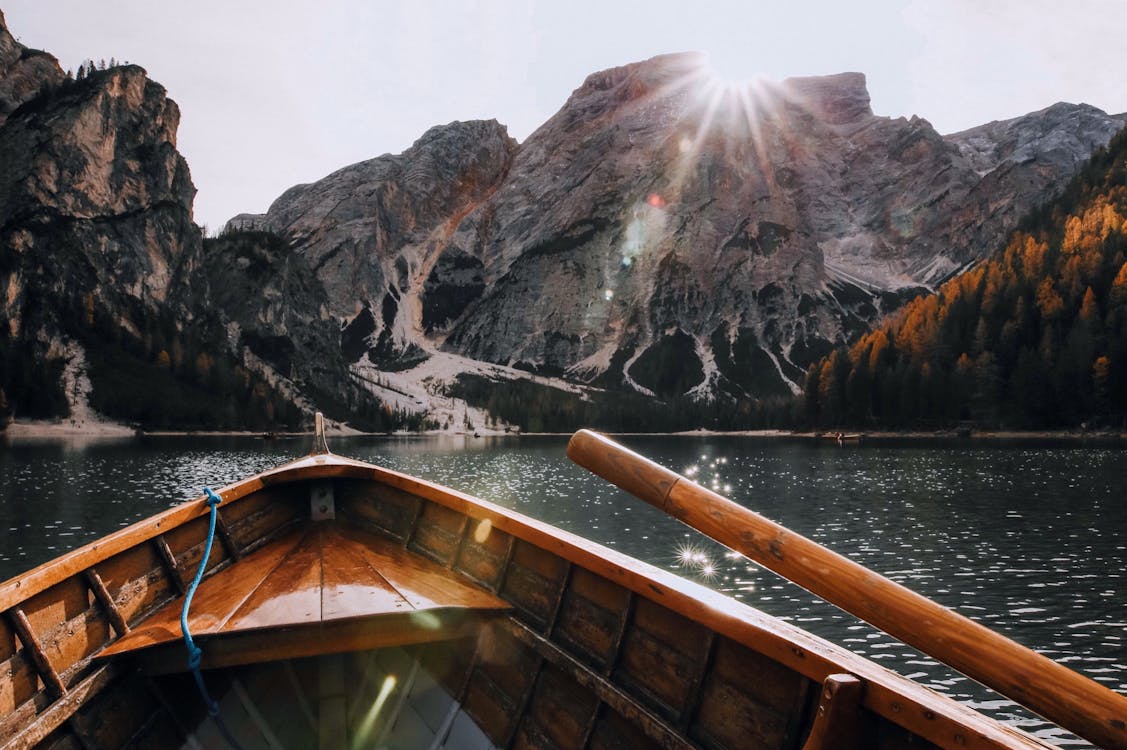 Free Brown Canoe in the Body of Water Near Mountain Stock Photo