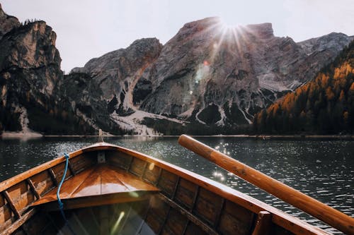 Free Brown Canoe in the Body of Water Near Mountain Stock Photo