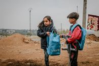 Poor ethnic children with crutches talking in rural areas under gloomy gray sky in daytime