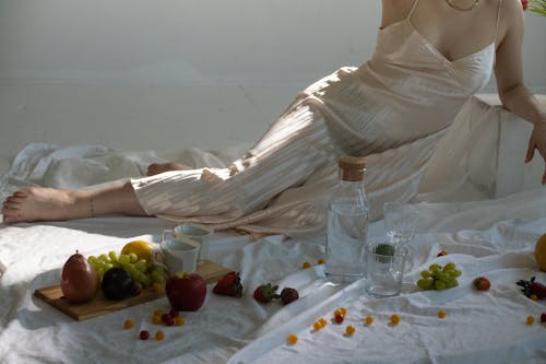 Woman resting near glassware and sweet fruits on wooden board