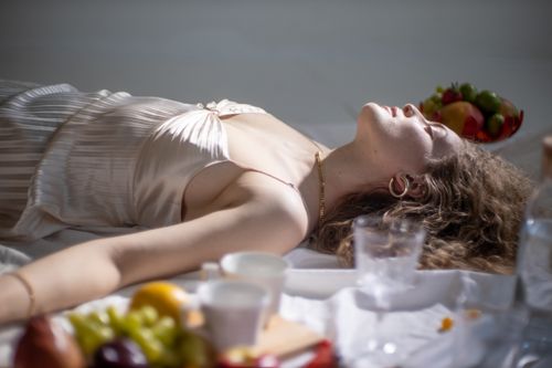 Free Young female with fair hair lying near sweet delicious fruits and utensil on white background Stock Photo