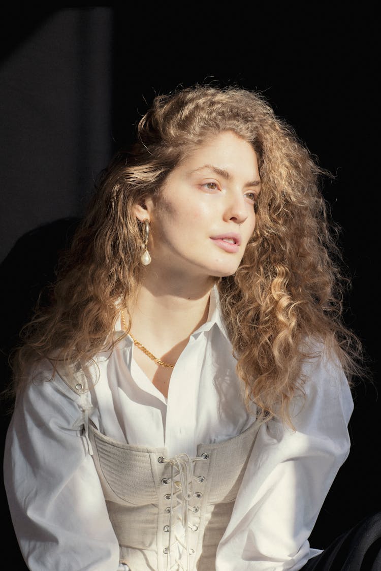 Elegant Young Lady Looking Away Dreamily In Dark Room