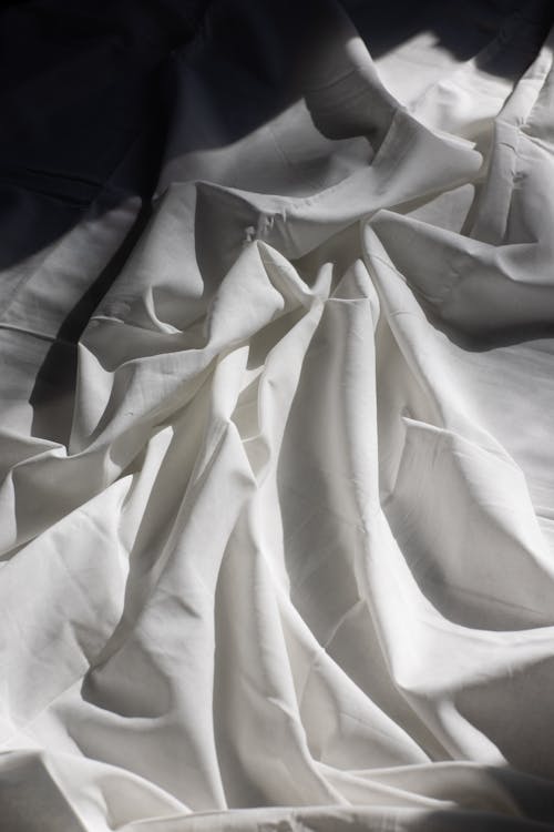 Draped fabric on bed in sunlight