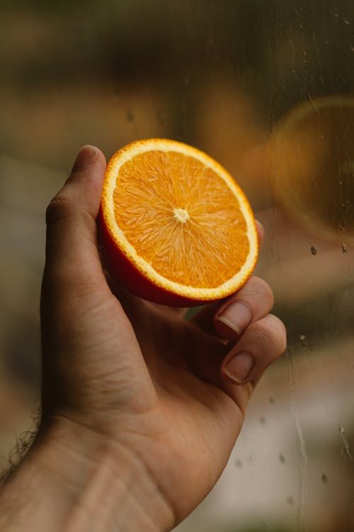 Free A Person Holding Orange Citrus Fruit Stock Photo