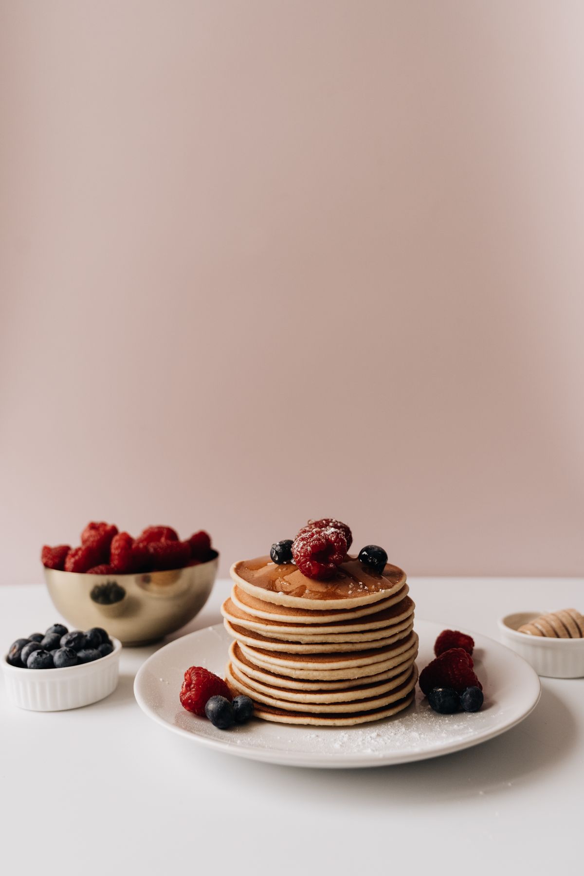 Reheated stack of pancakes topped with fresh berries on a plate