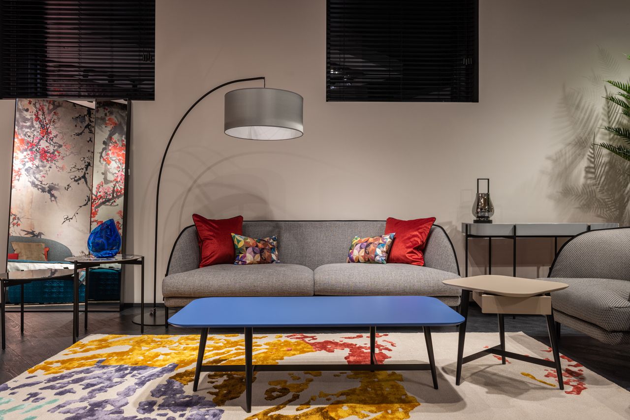 Sofa with colorful cushions near armchair and table