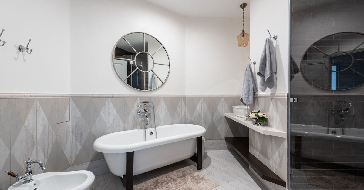 Interior of modern bathroom with glass shower and clean sink illuminated with bright lamp