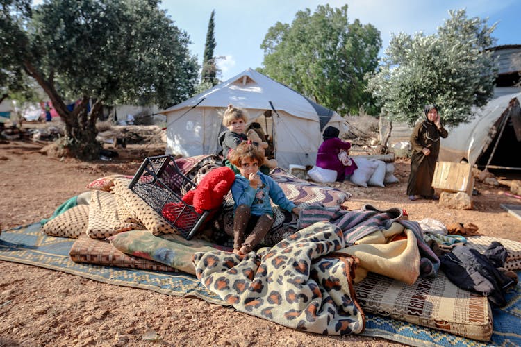 Children Sitting In Refugee Camp