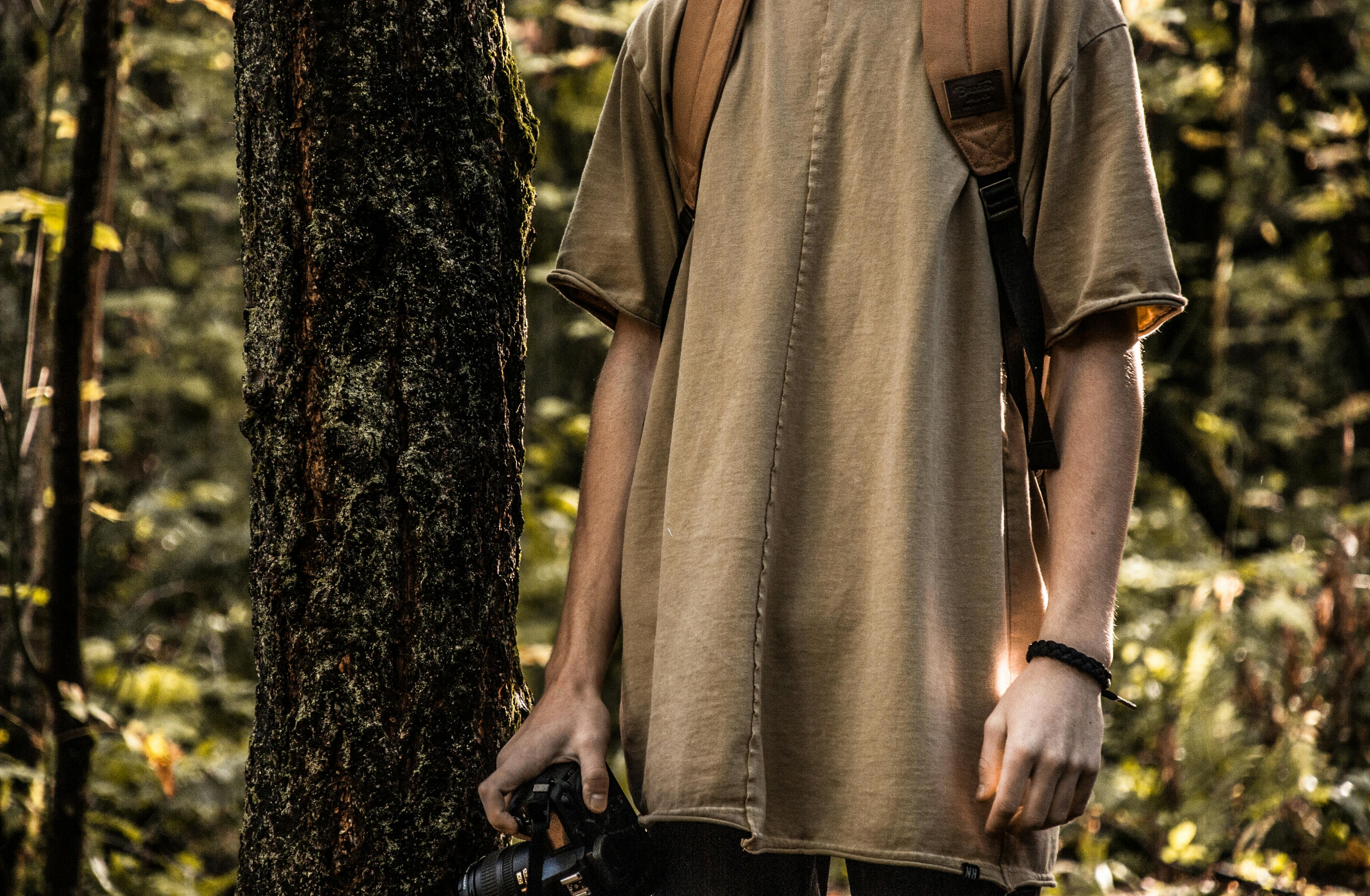 Persona En Camiseta Sosteniendo Una Cámara Dslr · Fotos de stock gratuitas