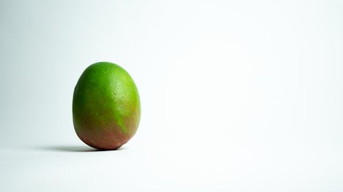 Green Oval Fruit on White Surface