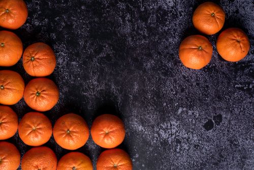Free Top view of ripe tangerines arranged on a dark surface, showcasing their vibrant orange color. Stock Photo