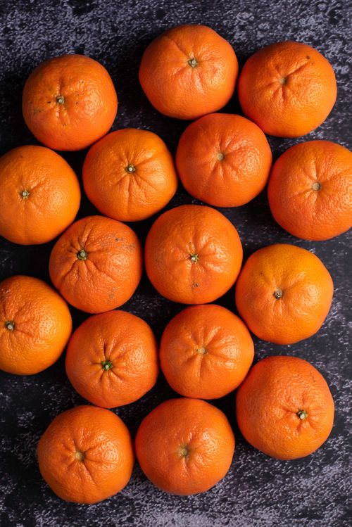 Free Fresh and juicy tangerines arranged on a dark textured background, showcasing vibrant colors. Stock Photo