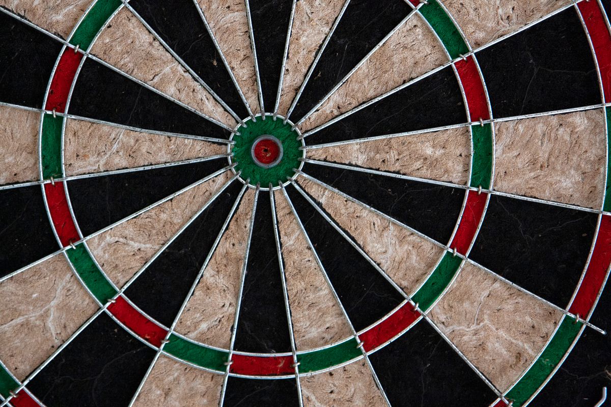 Close-up of a dartboard bullseye with colored rings, symbolizing precision and structured execution toward a goal