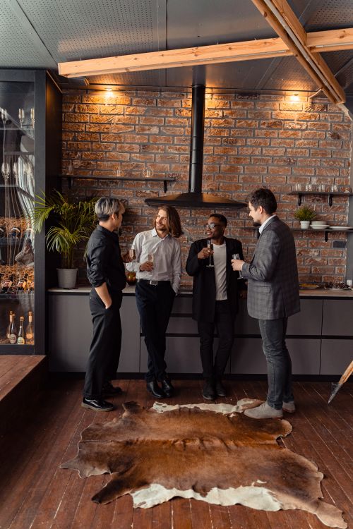 Free Four diverse adults enjoy a casual meeting in a stylish indoor lounge with brick walls. Stock Photo