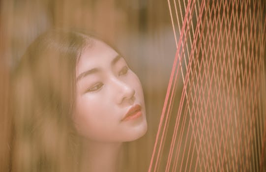 这幅宁静的肖像描绘了一位女性透过垂直的纱线凝视的画面，营造出梦幻般的效果