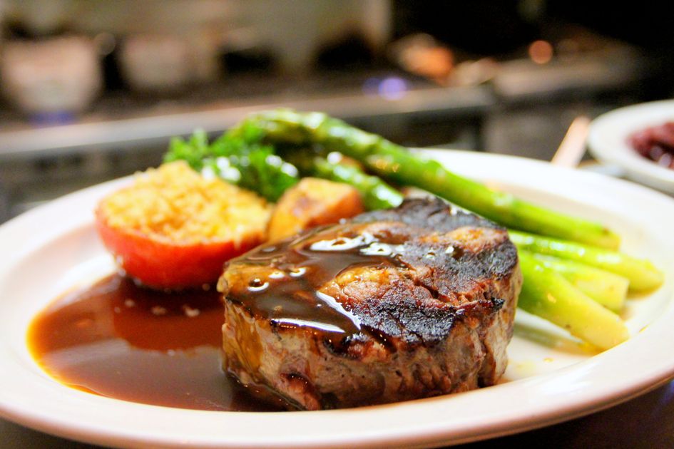Bife suculento grelhado com molho escuro em prato — dieta carnívora