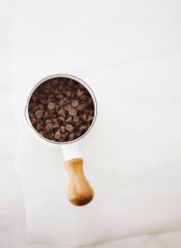 A minimalist shot of chocolate chips in a measuring cup, ideal for baking concepts.