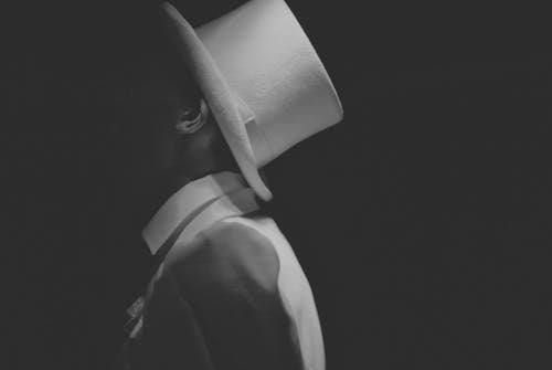 Gratis Hombre Vestido Con Sombrero Blanco Fotografía En Escala De Grises Foto de stock