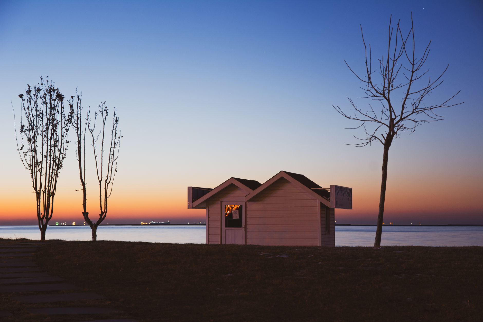 Peaceful sunset scene with a small house by the water in Qinhuangdao, China.