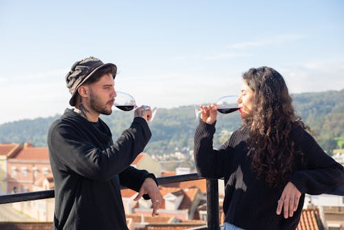 Man and Woman Wearing Black Long Sleeves Drinking Red Wine 