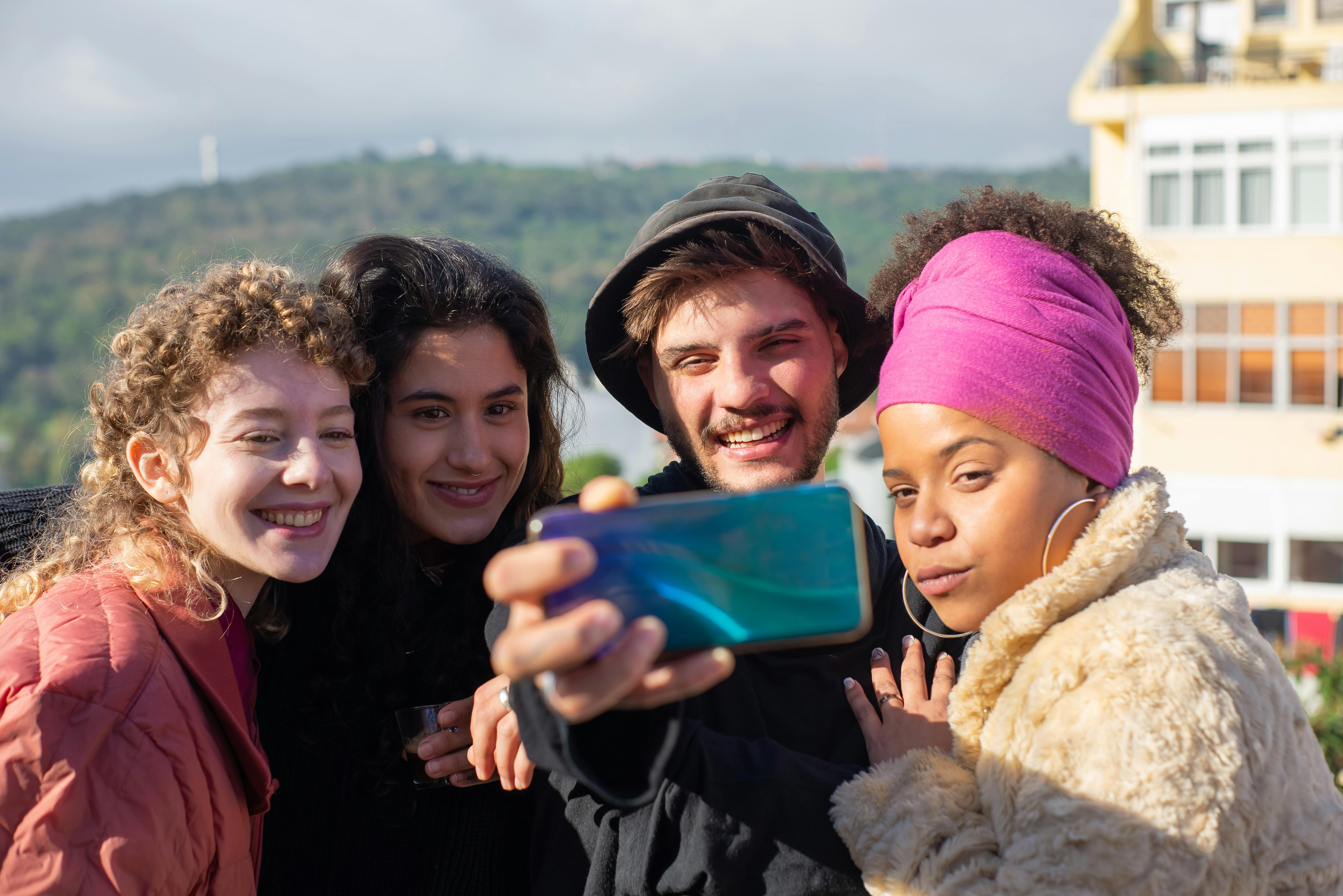 a group of people taking photo using a smartphone