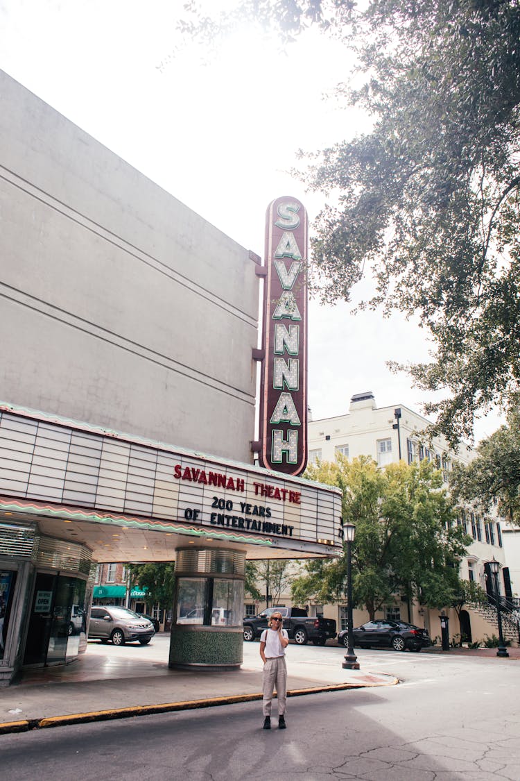 Person Standing In Front Of A Theater Building