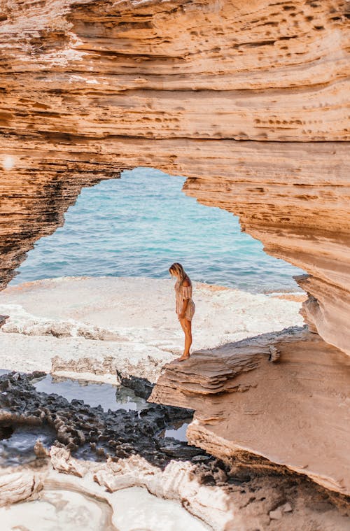 Drone Shot of a  Woman Standing on a Sandstone