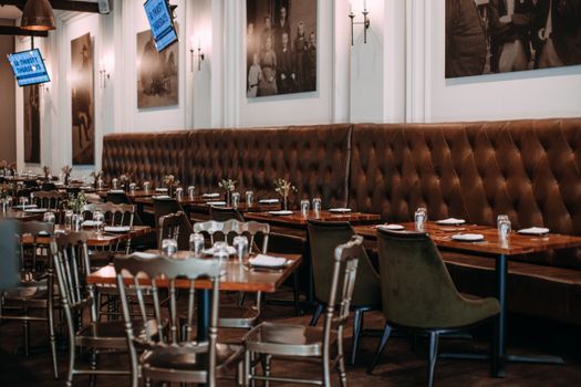Stylish restaurant setting with wooden tables and tufted leather seating. Elegant and inviting atmosphere.